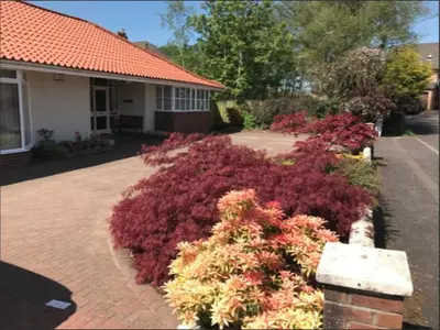 a garden of flowers in front of a house at The Clan MacGregor Room in Kilmarnock