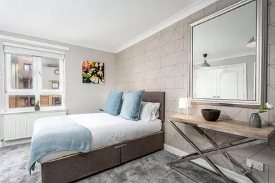 a bedroom with a bed and a desk and a window at Iona Residence - Donnini Apartments in Ayr