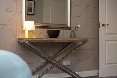 a mirror and a lamp on a shelf in a bathroom at Iona Residence - Donnini Apartments in Ayr