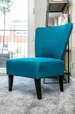 a blue chair sitting in a room at Iona Residence - Donnini Apartments in Ayr