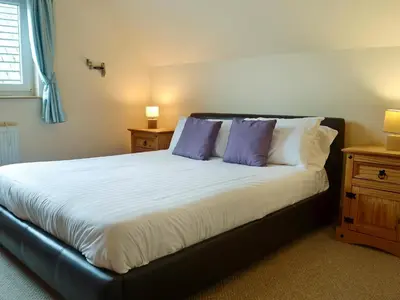 a bedroom with a bed with two purple pillows at Cressfield Villa in Ecclefechan