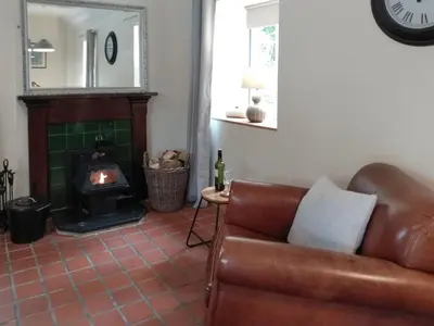 a living room with a couch and a fireplace at The Smiddy in Glasserton