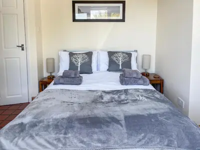 a bedroom with a large bed with two pillows at The Smiddy in Glasserton