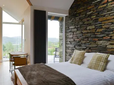 a bedroom with a stone wall and a bed at Cottam Road in Threlkeld