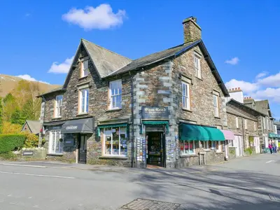 an old stone building on the side of a street at Easedale Corner in Grasmere