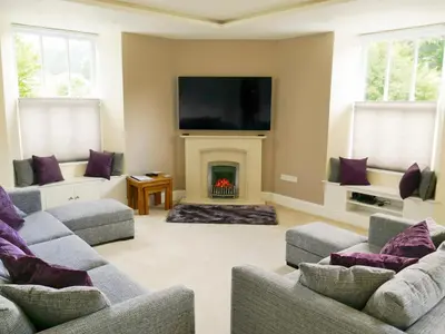 a living room with two couches and a fireplace at Easedale Corner in Grasmere