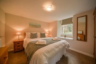 a bedroom with a bed with two towels on it at Blairquhan Cottages in Maybole