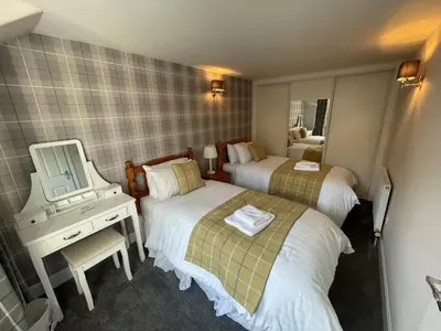 a hotel room with two beds and a mirror at Blairquhan Cottages in Maybole