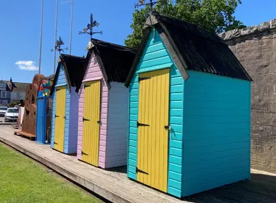 a row of colourful beach huts on a sidewalk at Providence Cottage in Kirkcudbright