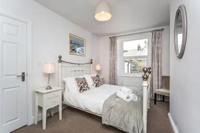 a bedroom with a white bed and a window at 5 The Townhouse in Keswick