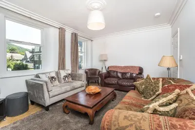 a living room with a couch a chair and a table at 5 The Townhouse in Keswick