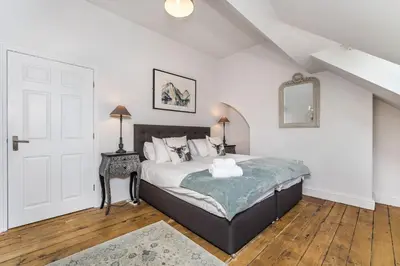 a bedroom with a bed and a table with a mirror at 5 The Townhouse in Keswick