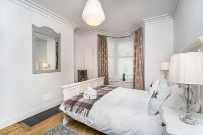 a white bedroom with a bed and a window at 5 The Townhouse in Keswick