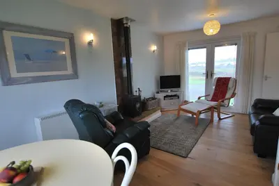 a living room with a couch and a table at 31 Laigh Isle in Isle of Whithorn