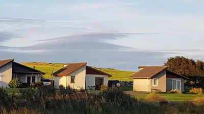 a row of houses in front of a vineyard at 31 Laigh Isle in Isle of Whithorn