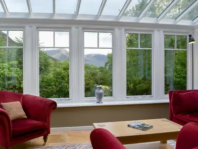 a room with a large window with a table and chairs at Trevene in Buttermere