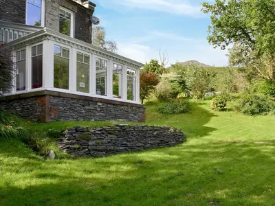 an exterior view of a house with a stone wall at Trevene in Buttermere