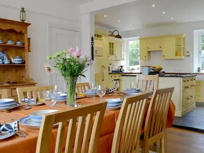 a kitchen with a table with a vase of flowers at Trevene in Buttermere