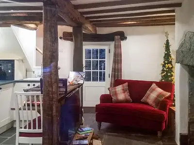 a living room with a red couch and a christmas tree at Field House Cottage - Uk12573 in Borrowdale Valley