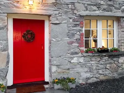a red door on a stone building with a window at Field House Cottage - Uk12573 in Borrowdale Valley