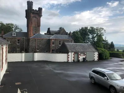 a car parked in a parking lot in front of a building at Laundry Cottage in Dumfries