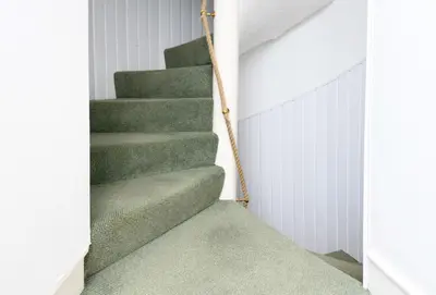 a staircase in a house with green carpet at Tower Lodge in Auchencairn