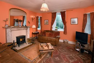 a living room with a couch and a fireplace at Tower Lodge in Auchencairn