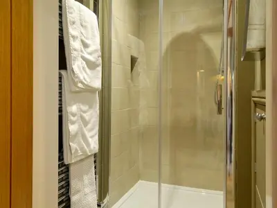 a bathroom with a shower with a glass door at The Hayloft in Caldbeck