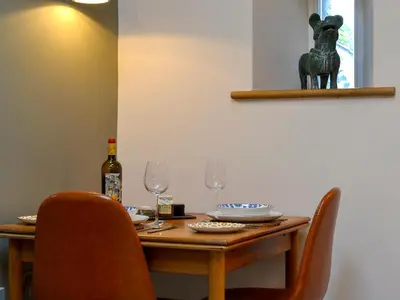a wooden table with chairs and a bottle of wine at The Hayloft in Caldbeck