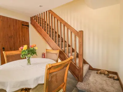a dining room with a table with a vase of flowers at The Barn in Workington