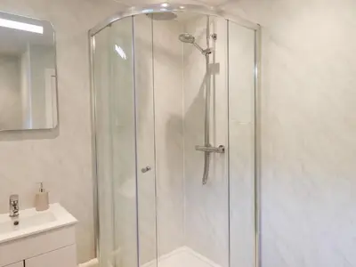 a shower with a glass door in a bathroom at Rock Cottage in Keswick