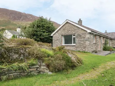 a stone cottage on the side of a hill at Rock Cottage in Keswick