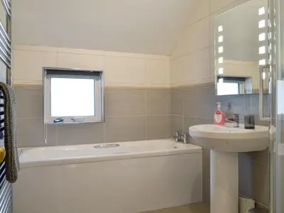 a bathroom with a tub and a sink and a bath tub at The Birches in Keswick