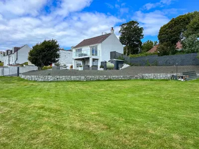 a white house with a lawn in front of it at Stinchar View in Ballantrae