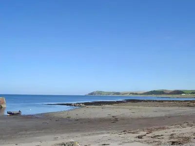 a beach with a boat in the water at Stinchar View in Ballantrae