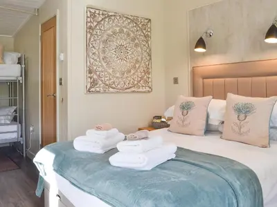 a bedroom with a bed with towels on it at Lapwing in Westward