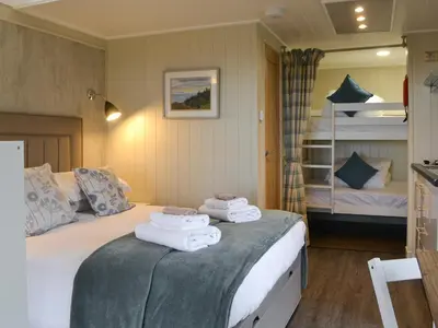 a bedroom with a bed with towels on it at Merlin's Cabin in Westward