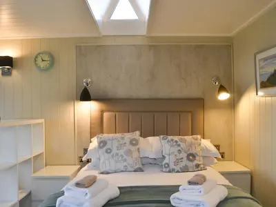 a bedroom with a bed with two towels on it at Merlin's Cabin in Westward