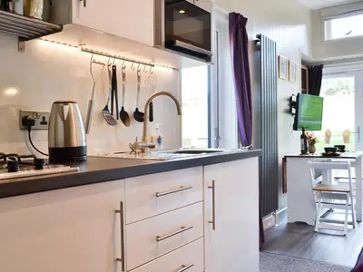 a kitchen with white cabinets and a sink at Curlew in Westward