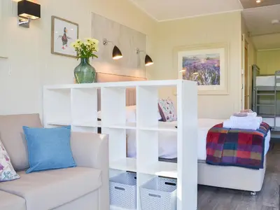 a living room with a white book shelf at Curlew in Westward