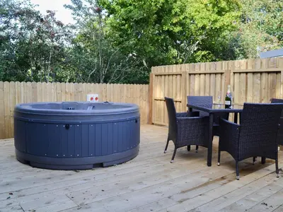 a large blue tub sitting on a patio with chairs and a table at Curlew in Westward