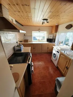 a kitchen with a sink and a washing machine at Mona Villa Holiday Home in Coulderton