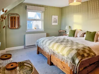 a bedroom with a large bed and a window at Saffron in Portpatrick