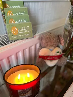 a candle in front of a refrigerator with a teddy bear at Rockhill Guest House in Moffat