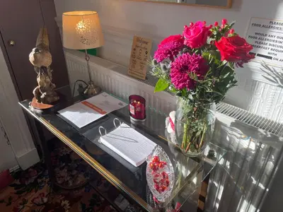 a glass table with a vase of flowers on it at Rockhill Guest House in Moffat