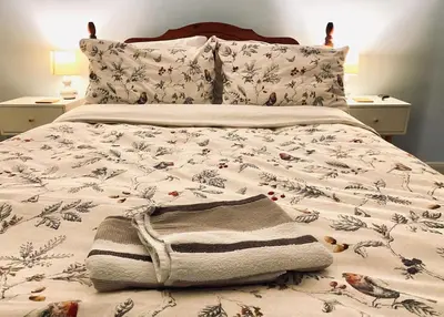a bed with a comforter with a blanket and a towel on it at Rose Cottage in Wigton