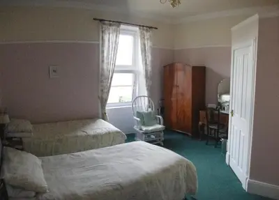 a bedroom with two beds and a window at The Old Rectory in Annan