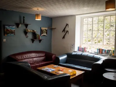 a restaurant with a leather couch and a table at YHA Helvellyn in Glenridding