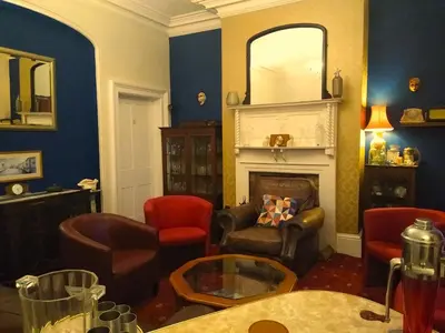 a living room with chairs and a fireplace at Green View Guest House in Silloth