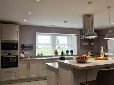 a kitchen with white cabinets and a bowl of fruit on a counter at Torcross Barn in Tarbolton